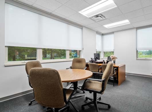 Designer Roller Shades Halfway in Office